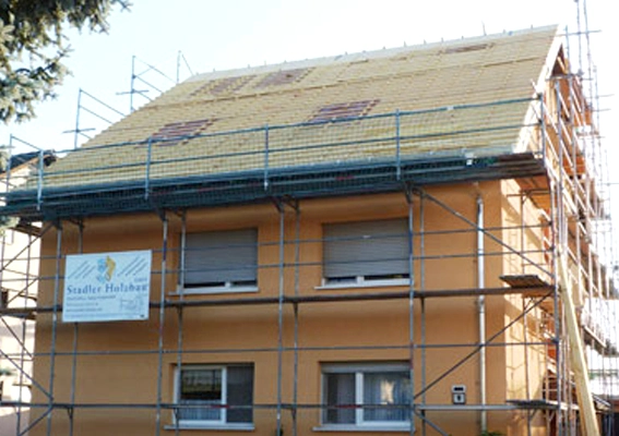 Ein Dach eines Familienhauses wird neu eingedeckt